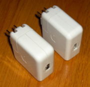 Two iPod wall chargers, with FireWire (left) and USB (right) connectors, which allow iPods to charge without a computer.