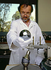 Shown above, one of the master opticians at the Australian Centre for Precision Optics (ACPO) is holding a 1&nbsp;kg, single-crystal silicon sphere for the Avogadro project. These spheres are among the roundest man-made objects in the world. If the best of these spheres were scaled to the size of Earth, its high point&mdash;a continent-size area&mdash;would gently rise to a maximum elevation of only 2.4 meters above &ldquo;sea level&rdquo;.