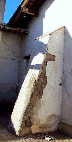 An original exterior wall buttress at Mission San Miguel Arc&aacute;ngel, which suffered extensive earthquake damage on December 22, 2003. Sections of the plaster finish coat have sloughed off, exposing the adobes beneath to the elements.