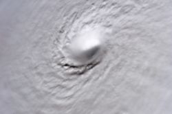 A picture of Hurricane Wilma's eye taken at 08:22 CDT (13:22 UTC) October 19, 2005, by the crew aboard the International Space Station. At the time, Wilma was the strongest Atlantic hurricane in history, with a minimum central pressure of only 882 mbar (26.06 inHg). Not only is this a classic example of a pinhole eye, but also of the stadium effect, where the eyewall slopes out and up.