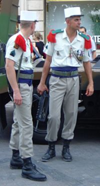 L&eacute;gionnaires in dress uniform. Note the red epaulettes and the distinctive white kepi. They carry the standard assault rifle, the FAMAS.