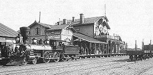 A Hanko-Hyvink&auml;&auml; railway Baldwin 4-4-0 of 1872 vintage in front of the station building in Hanko in 1893.