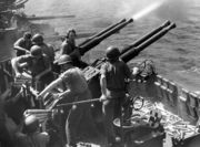 Bofors 40&nbsp;mm anti-aircraft guns on a MK 12 quadruple mount fire from the deck of the USS&nbsp;Hornet in World War II.
