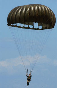 An American paratrooper using an MC1-1C series 'round' parachute
