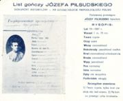 1928 reproduction of an 1887 Tsarist Russian wanted poster for Piłsudski, distributed (presumably by his political enemies) "on the 10th anniversary of Poland's independence": Translation  &nbsp;"State criminal J&Oacute;ZEF PIŁSUDSKI, nobleman DESCRIPTION: Age 19 (1887) Height 1 meter, 75 cm. Face clear Eyes grey Hair dark-blond Sideburns light-blond, sparse Eyebrows dark-blond, fused Beard dark-blond Mustache light-blond Nose normal Mouth normal Teeth missing some Chin round Distinctive marks: 1) clear face, with eyebrows fused over nose, 2) wart at the end of right ear"