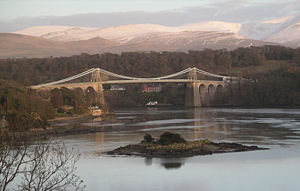 The Menai Strait in 2004 crossed by a suspension bridge, with Eryri in the background. Control of the Menai and access to Ynys M&ocirc;n was crucial for medieval Gwynedd.